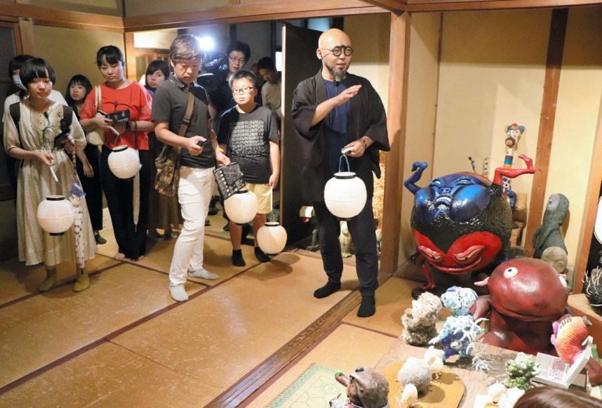 プレスツアーで柳生さん（右端）の説明を受けながら妖怪美術館の展示作品を見て回る報道関係者ら＝土庄町