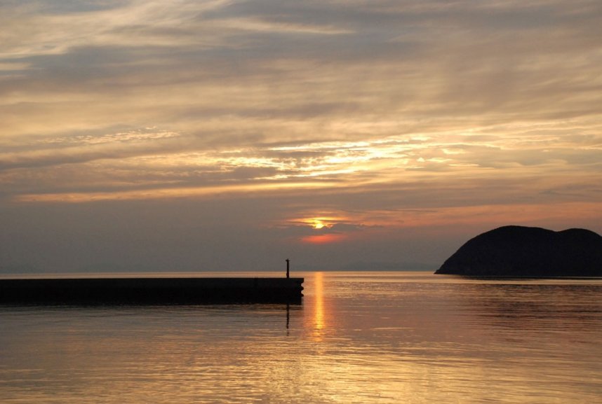 仁尾港に沈む夕日。右手には丸山島が見える＝香川県三豊市仁尾町