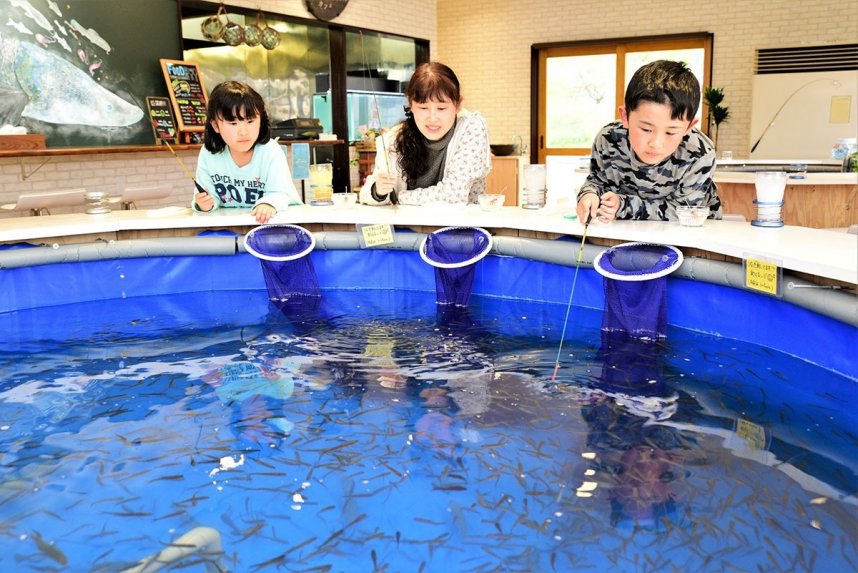 店内のいけすで釣りを楽しむ家族連れ＝三豊市三野町