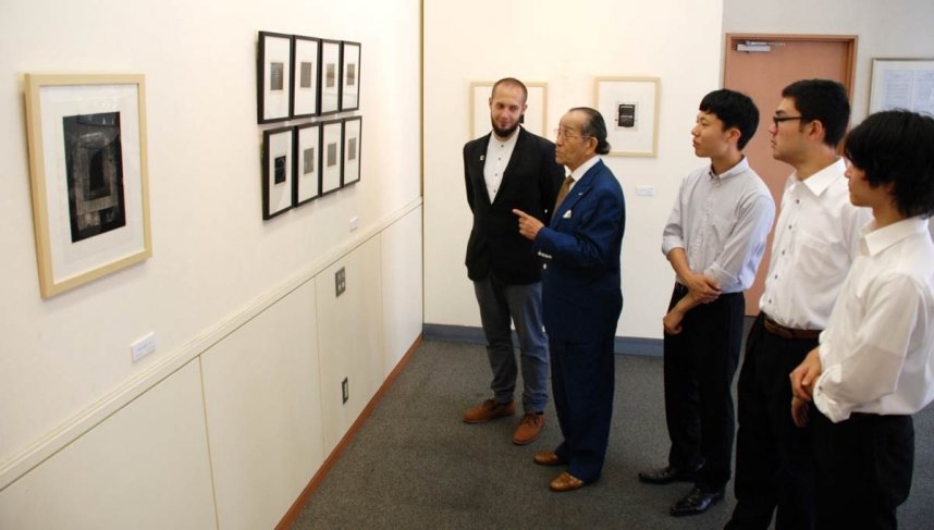 マステルナクさん（左）の説明を受けながら作品を鑑賞する浜野さん（左から２番目）と来場者＝高松市松島町