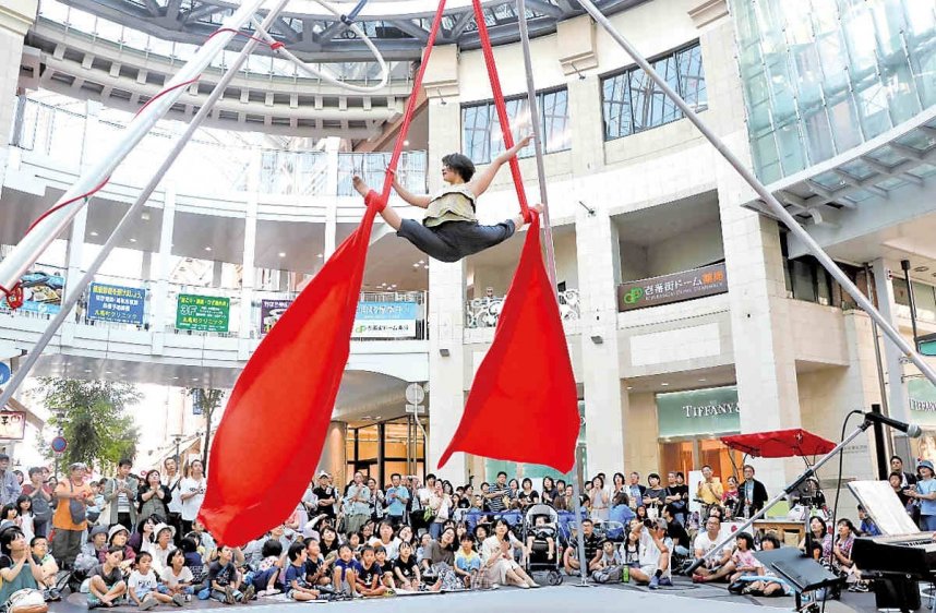 地上6メートルの高さで繰り広げられる妙技を楽しむ家族連れら＝高松市丸亀町