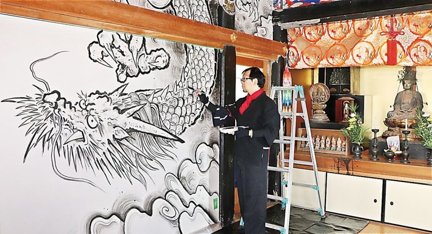 本堂の壁面に龍神図を描く斎灯さん＝香川県土庄町上庄、宝生院