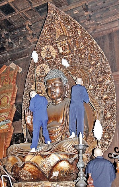 本尊・薬師如来坐像のほこりを払う僧侶＝香川県善通寺市、総本山善通寺