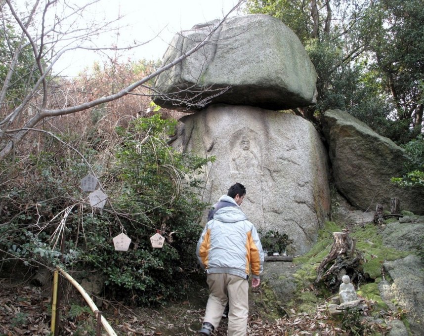 上の岩が今にも落ちそうで落ちないゆるぎ岩観音＝丸亀市本島町