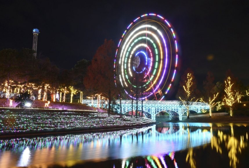 夜空に描かれた色とりどりの光跡。水面にも鮮やかに映し出されている＝香川県丸亀市綾歌町、ニューレオマワールド