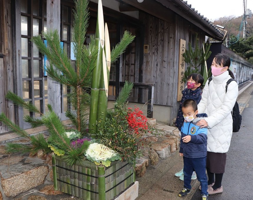 新春の華やかさを感じさせる門松に見入る観光客＝香川県小豆島町田浦、二十四の瞳映画村