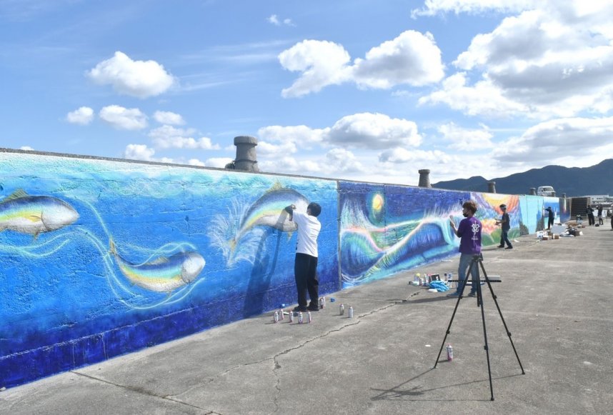 防波堤をキャンバスに作品制作に取り組むスプレーアーティスト＝東かがわ市引田、引田漁港