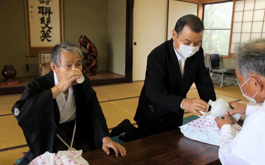 出来たてのどぶろくを口にして味を確かめる大宮宮司（左）ら＝香川県三豊市豊中町、宇賀神社