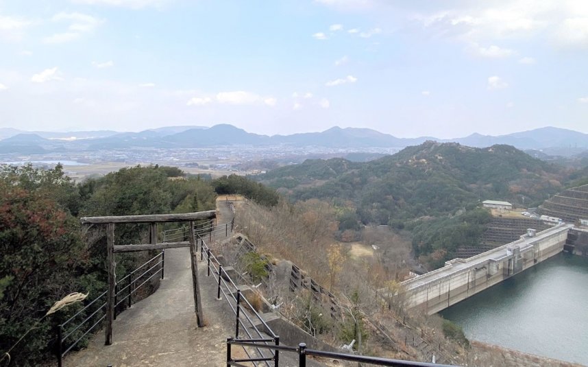 山上公園の遊歩道から、門入ダムと鳥居越しにさぬき市の街並みを望む