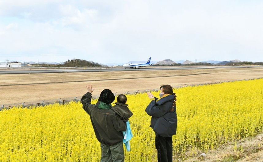 着陸した飛行機に手を振る親子連れ