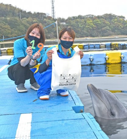 開業19周年記念イベントをアピールする施設スタッフとイルカ＝香川県さぬき市津田町、日本ドルフィンセンター