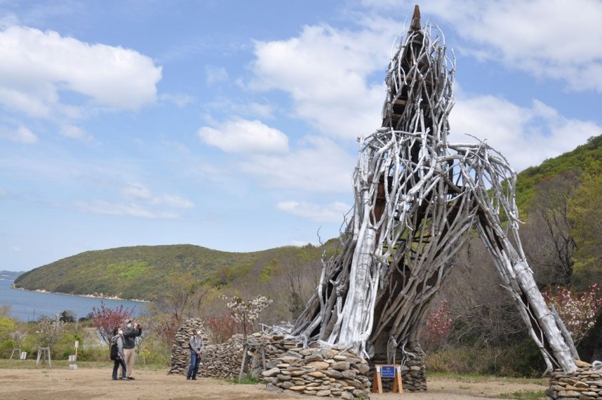 巨人像「ダイダラウルトラボウ」を見上げる来場者＝香川県小豆島町神浦