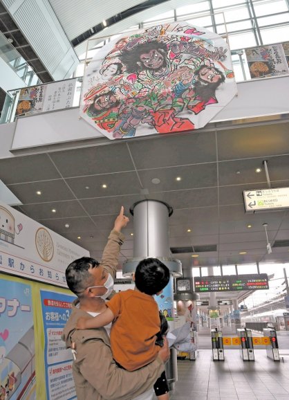 巨大なねぷた絵に見入る乗降客＝香川県高松市浜ノ町、ＪＲ高松駅