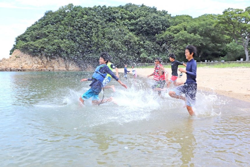 水しぶきを上げて海に飛び込む海水浴客＝香川県坂出市沙弥島、沙弥海水浴場