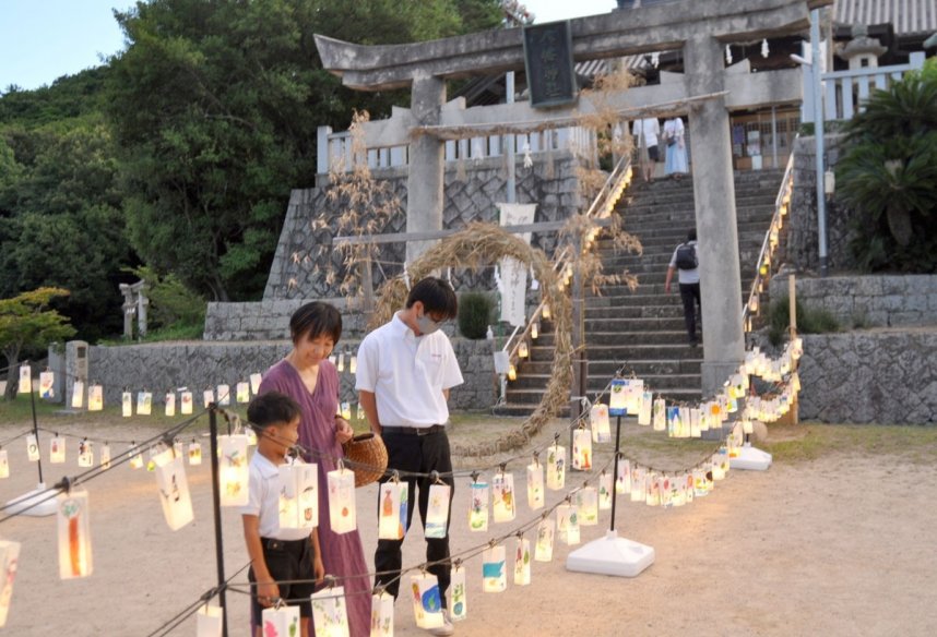 地元の児童たちが手作りしたあんどんを見ながら参拝する家族連れら＝香川県土庄町、土庄八幡神社
