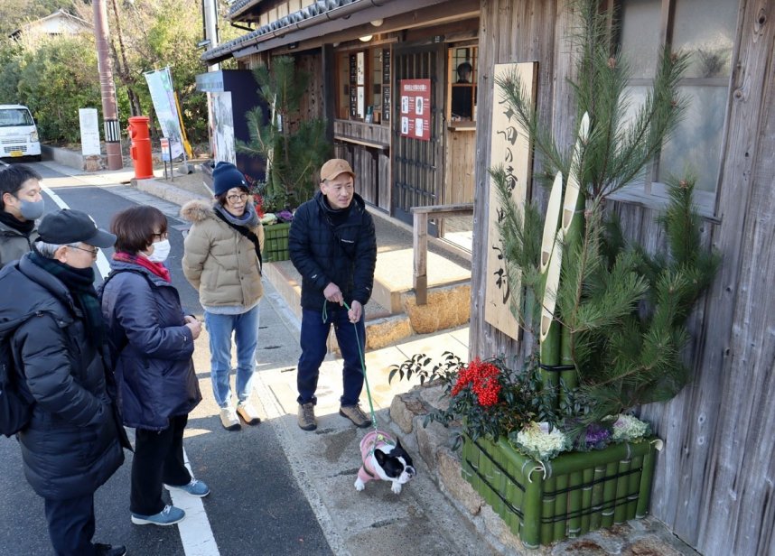 設置されたばかりの手作りの門松に見入る観光客＝香川県小豆島町田浦、二十四の瞳映画村