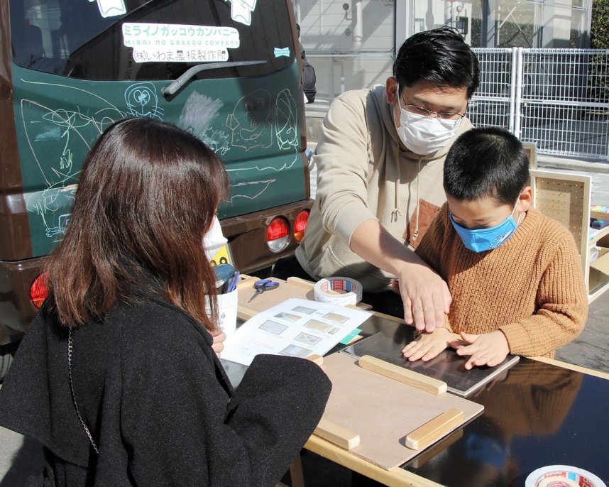 協力して黒板作りに取り組む親子＝香川県善通寺市文京町