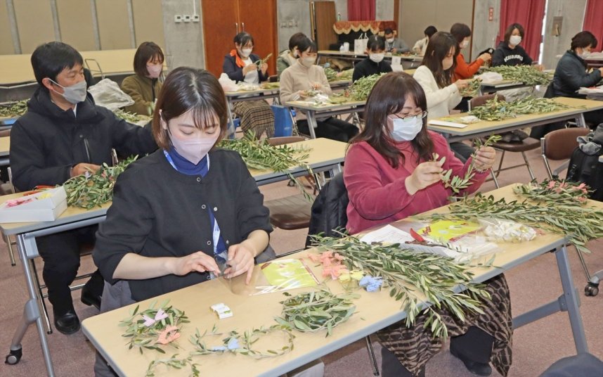 オリーブの枝を丸めてリース作りに取り組む観光関係施設の従業員ら＝小豆島町西村、小豆島オリーブ公園