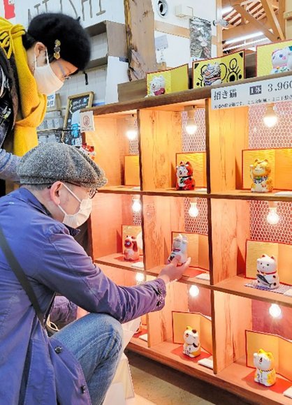 香川、徳島両県の作家が制作した「招き猫」を品定めする買い物客＝香川県高松市牟礼町、道の駅源平の里むれ