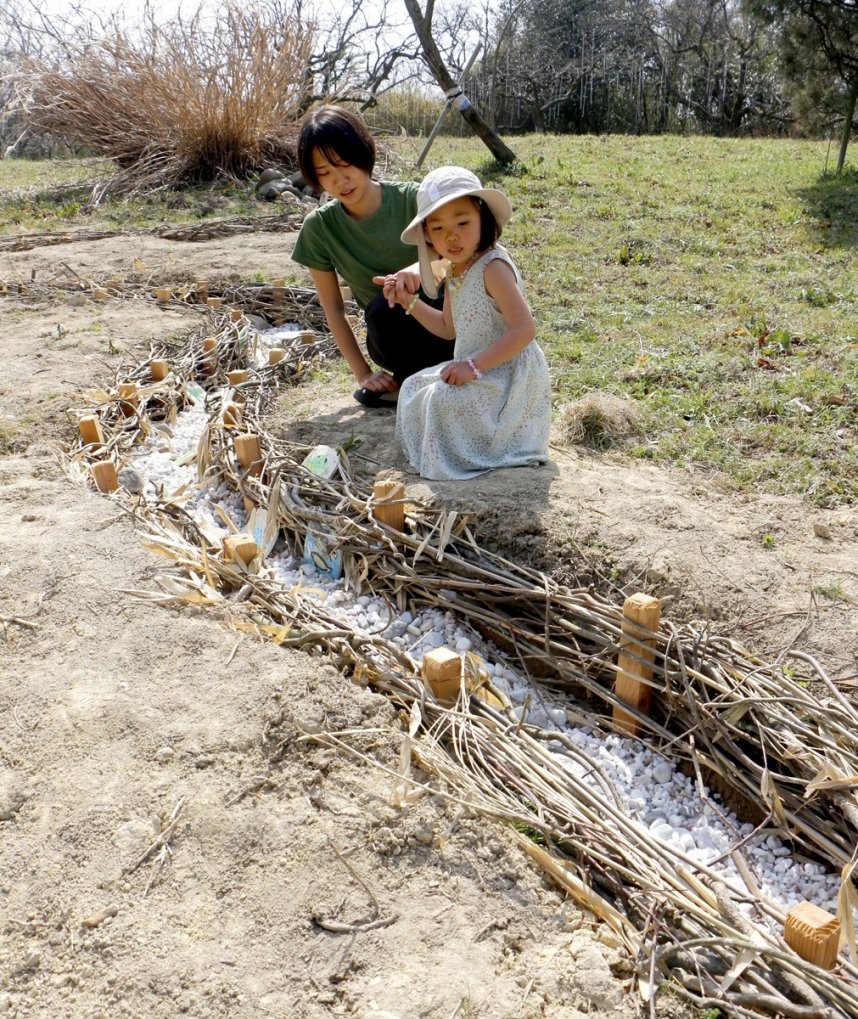 小川を表現した作品を楽しむ親子＝香川県まんのう町造田、山のウーフ