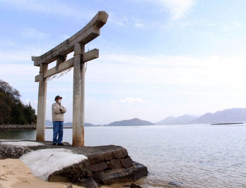 浜辺に立つ馬城八幡神社の鳥居。満潮時は基礎部分の黒ずんでいる辺りまで波が打ち寄せるという＝粟島