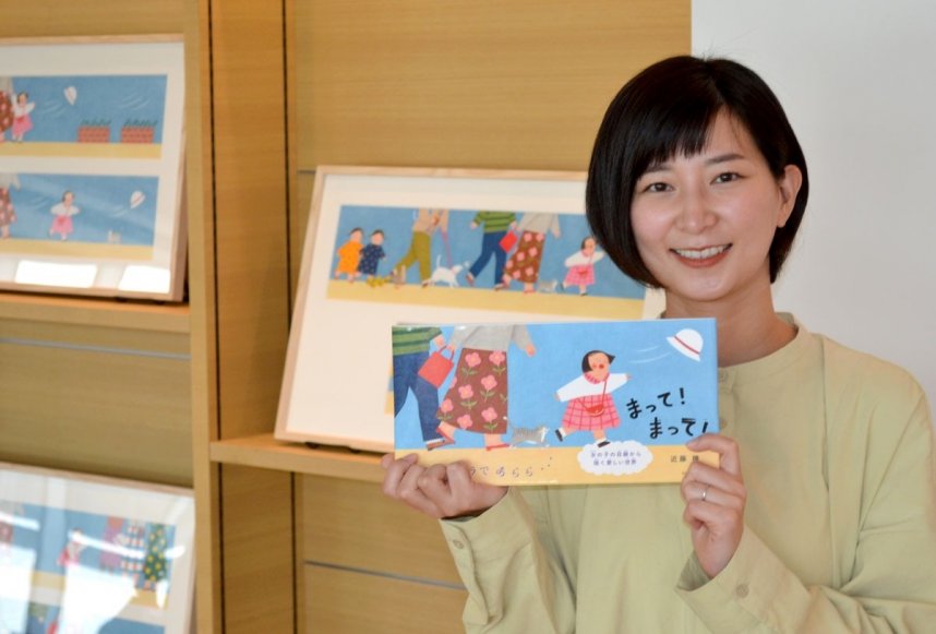 デビュー作の絵本を手に笑みを浮かべる近藤さん＝香川県丸亀市大手町、市民交流活動センター「マルタス」