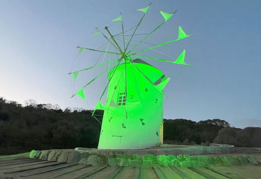 実験点灯で夜空に緑色に浮かび上がるギリシャ風車＝香川県小豆島町西村、小豆島オリーブ公園