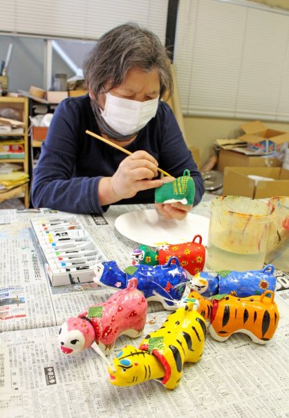 胡粉を塗った胴体の土台に、好きな色や模様を絵筆であしらう＝香川県三豊市三野町、田井民芸