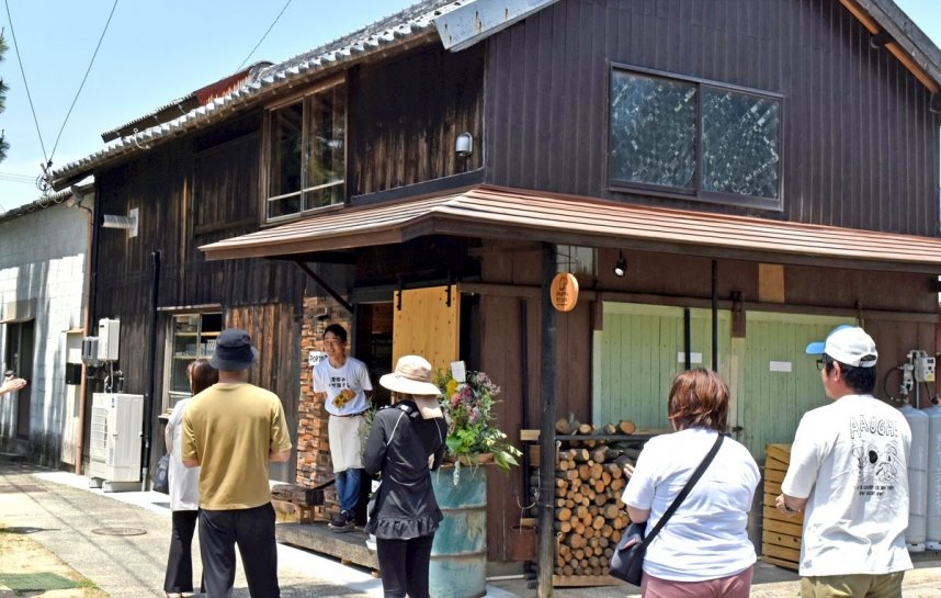 ピザ店のオープンを来店客に告げる店長の折口さん（中央奥）＝香川県さぬき市津田町