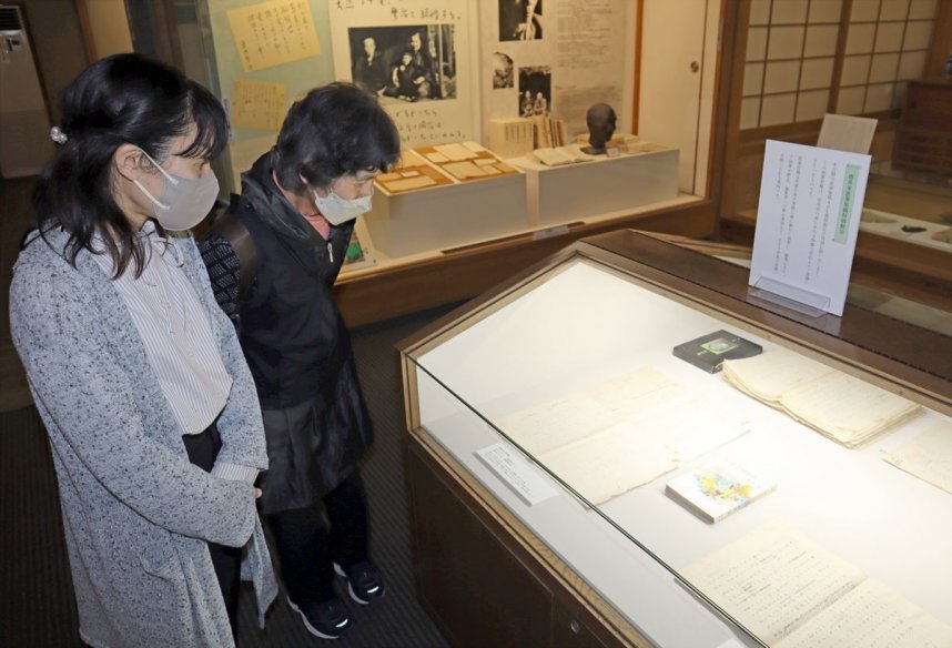 壺井栄の直筆原稿に見入る家族連れ＝香川県小豆郡小豆島町田浦、二十四の瞳映画村内の壺井栄文学館