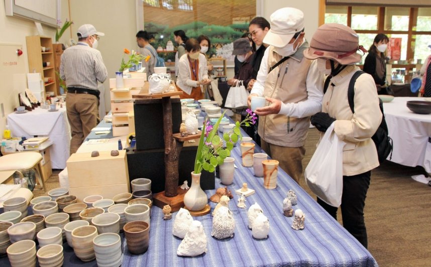 個性豊かな陶芸作品を手に取って品定めする来場者＝香川県高松市栗林町、栗林公園商工奨励館