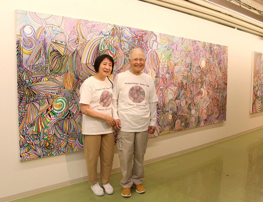 「宇宙シリーズ」の大作の前で笑顔を見せる川島猛と妻の順子さん＝香川県高松市亀水町、川島猛アートファクトリー