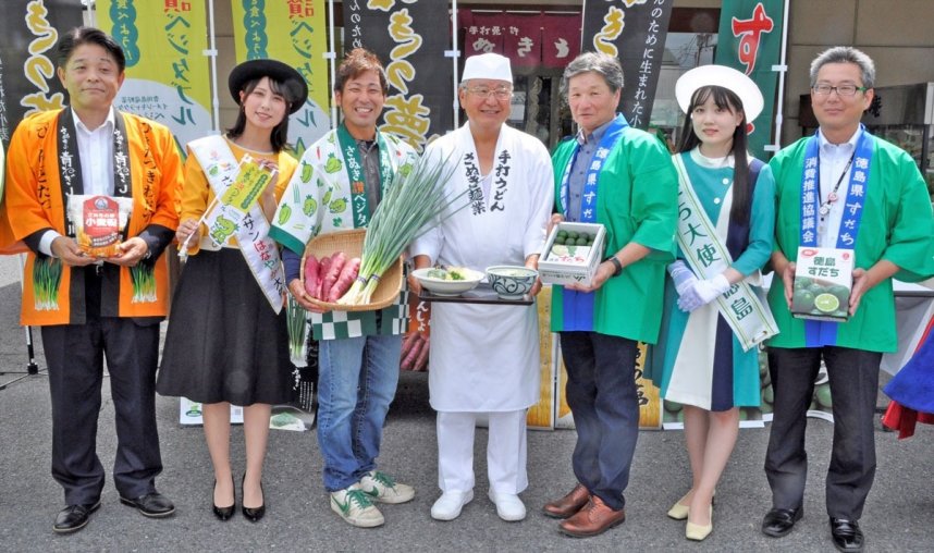 生産者から青ネギとサツマイモ、スダチを受け取った香川社長（中央）＝香川県高松市松縄町