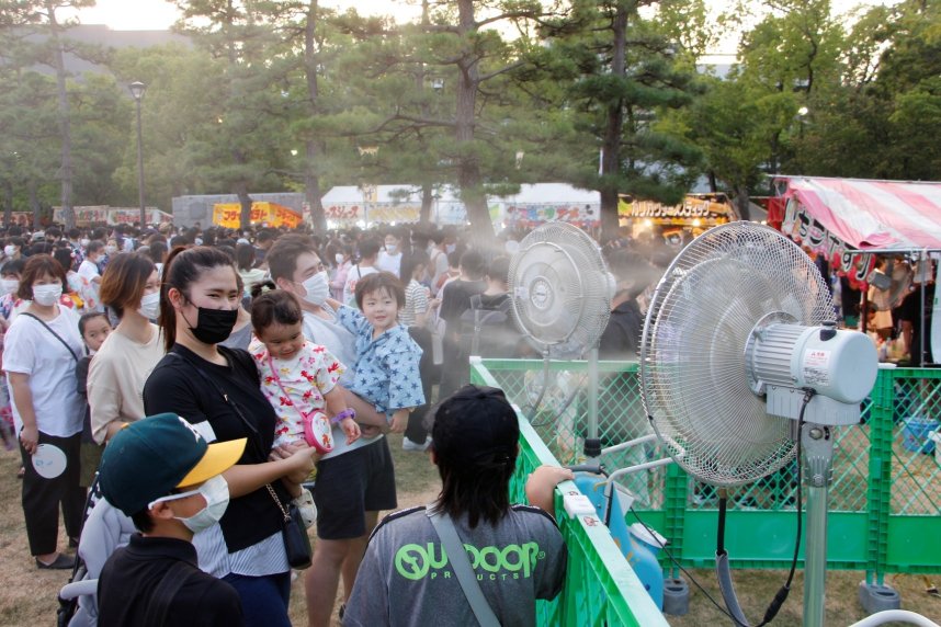 ミスト扇風機で涼をとる来場者＝高松市中央公園