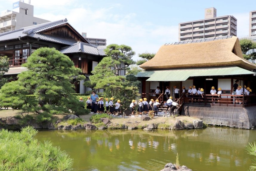 かやぶき屋根がふき替えられた時雨亭を見学する児童ら＝香川県坂出市本町、香風園