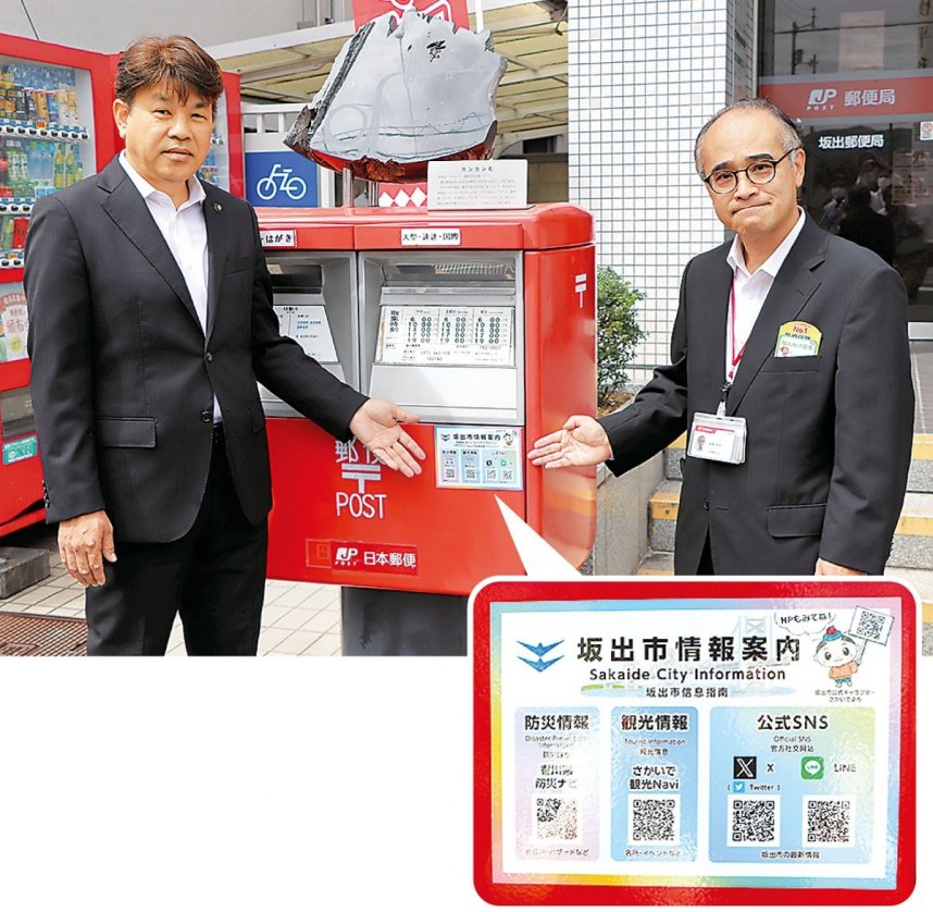 坂出郵便局前のポストに情報案内用ステッカーを掲示する有福市長（左）と越智局長＝香川県坂出市京町