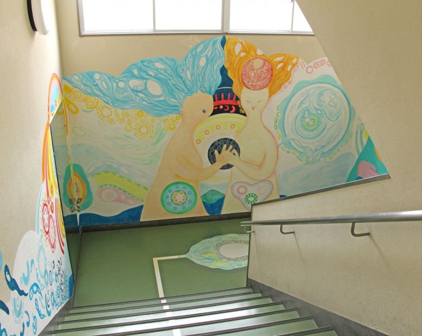 ２階につながる階段の壁に描かれた、生命をテーマにした絵画