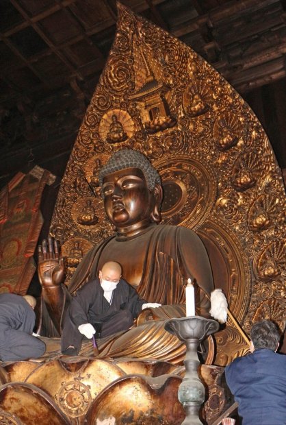 薬師如来坐像のほこりを落とす僧侶ら＝香川県善通寺市、総本山善通寺