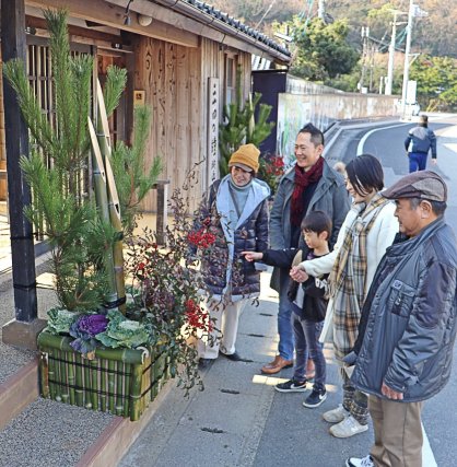 飾り付けられたばかりの華やかな門松に見入る家族連れ＝香川県小豆郡小豆島町田浦、二十四の瞳映画村