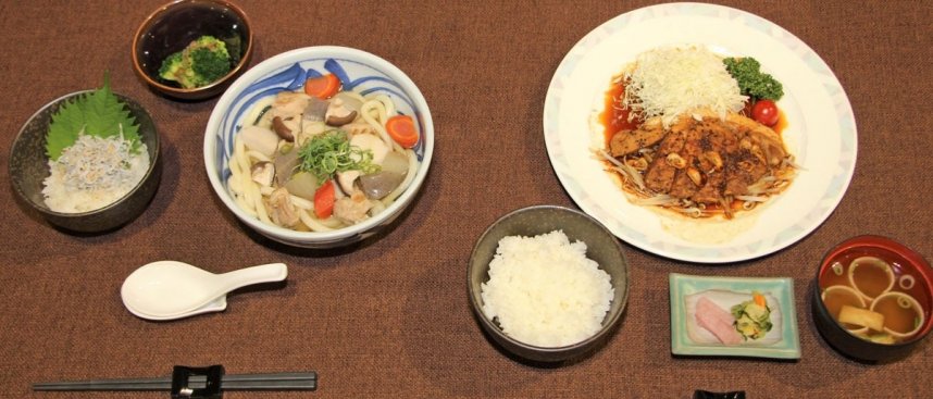 「四国うどんとブロッコリーの和え物」（左）と「満足トンテキ」