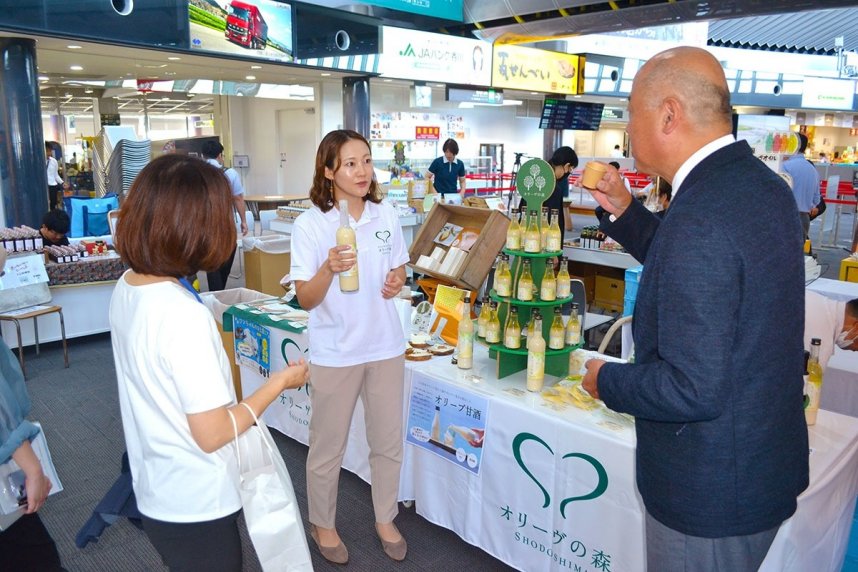 「讃岐のイッピン！」の販売会で自社商品を説明する事業者＝高松市香南町、高松空港