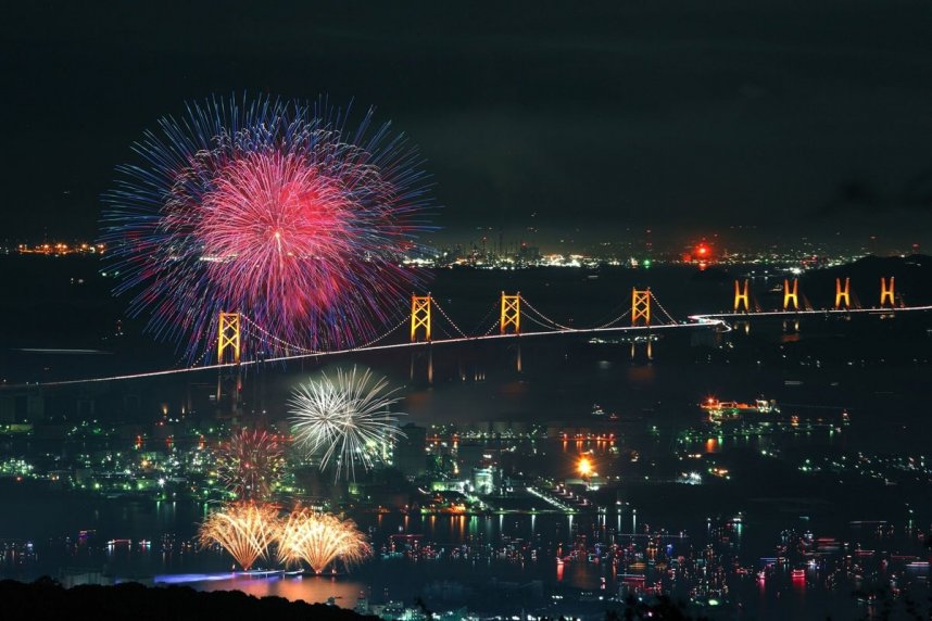 瀬戸大橋を背景に、海上に広がる夜空を鮮やかに焦がす海上花火大会（資料）