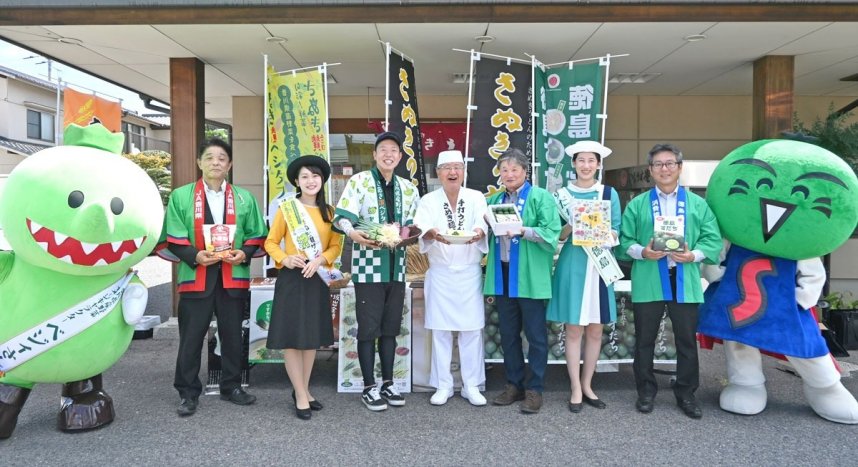 生産者から青ネギとサツマイモ、スダチを受け取った香川社長（中央）＝香川県高松市松縄町