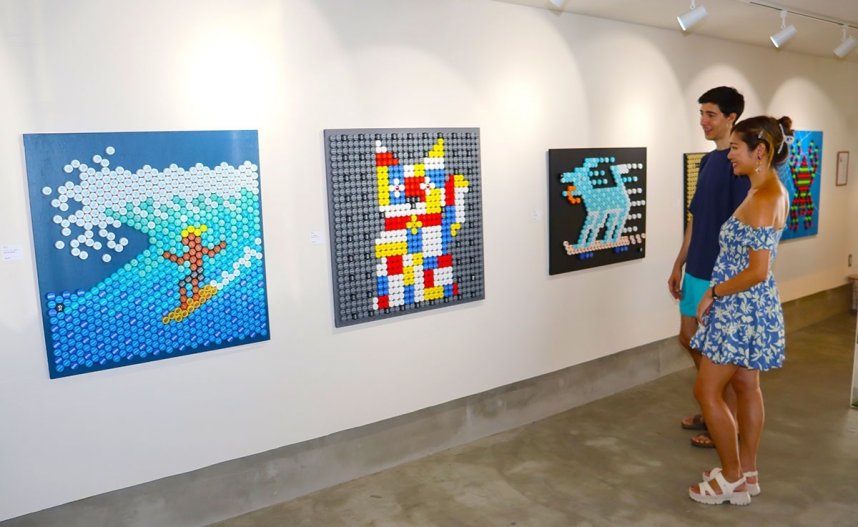 ペットボトルのキャップを使ってデザインした作品に見入る来館者＝土庄町、ファイン・ポート・ギャラリー