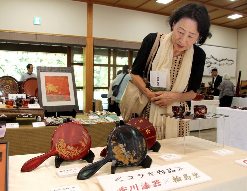 香川漆器と輪島塗のコラボレーション作品を鑑賞する来場者＝香川県高松市、栗林公園商工奨励館