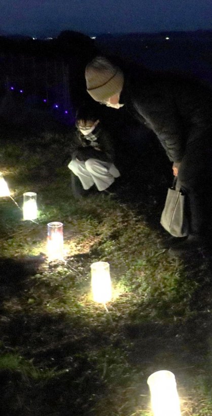 子どもたちが豊島への思いを込めてデザインしたランプに見入る家族連れ＝香川県小豆郡土庄町豊島唐櫃