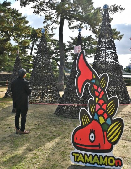 玉藻公園にお目見えした松ぼっくりツリーとパネル＝香川県高松市玉藻町
