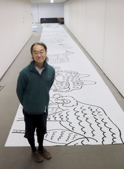 長くつないだ模造紙に動物を描き、壁面を彩るインスタレーション作品を制作する山口さん＝坂出市寿町、市民美術館