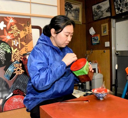 漆を塗った後に指先で模様を付ける繊細な作業に取り組む後藤さん