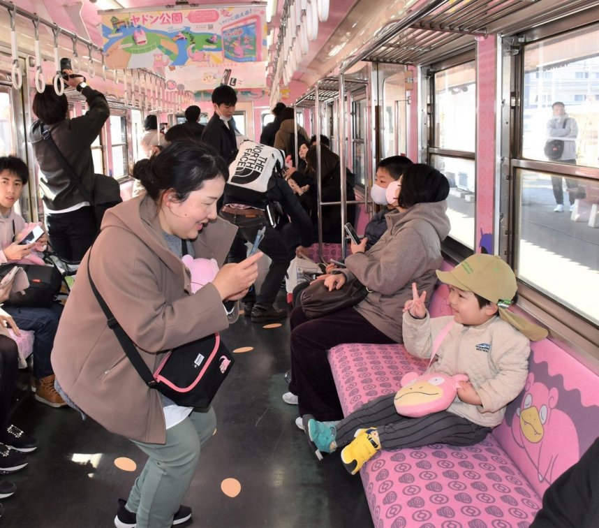 ヤドンの列車に試乗し、写真撮影を楽しむ県内外のファンら＝香川県高松市仏生山町、仏生山駅
